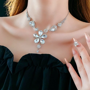 Macro detail of a silver flower necklace with sparkling crystals on a model's neck