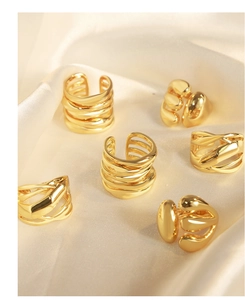 Macro view of gold minimalist irregular open rings on elegant silk fabric texture