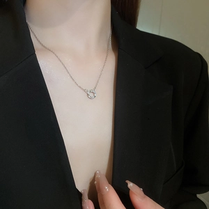 Silver necklace with cubic zirconia circle pendant shown on model in black suit