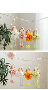 Detailed view of four colorful fairy dolls hanging on a branch for Easter decor