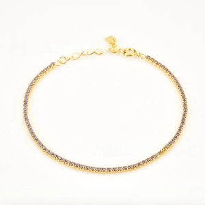 Tennis bracelet detail with purple cubic zirconia stones on a gold plated chain