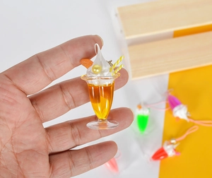 Λεπτομέρεια από πολύχρωμα resin charms επιδορπίου με κρέμα και μίνι καλαμάκι
