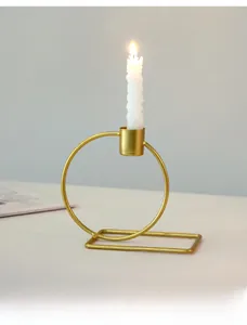 Detail view of a Nordic gold geometric metal candle holder with a spiral white candle