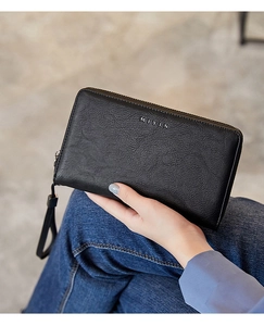Close-up of black textured leather RFID long wallet with wristlet and silver logo