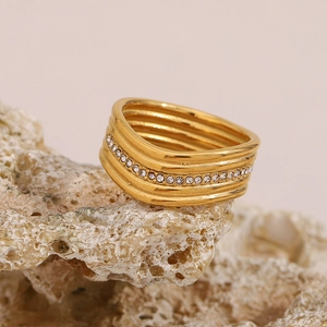 Dettaglio macro dell'anello dorato multi-strato a spirale con pietre di zircone micro-pave