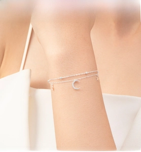 Close-up of a double-layer S925 silver bracelet with star and crescent moon pendants