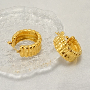Minimalistische goldene U-förmige Edelstahl-Ohrringe mit Wellentextur auf weißer Seide