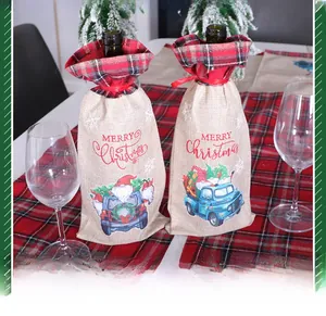 Détail de housses de bouteille de vin en lin avec motif Père Noël et bordure à carreaux rouges
