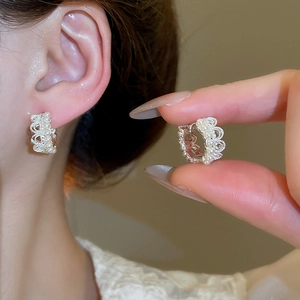 Detailed macro view of French vintage silver lace earrings with white pearls