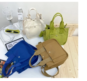 Detail view of four casual canvas tote bags in beige, green, blue and brown colors