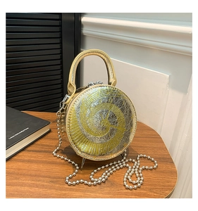 Detail showing the swirling metallic texture and chain strap of this round clock bag
