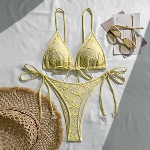 Detail of light yellow textured bikini with halter ties and pearl bead accents