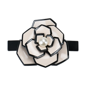 Detail of camellia hair clip with beige and black acetate petals and a center pearl