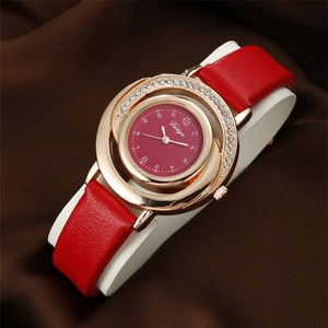 Close-up of red leather strap watch with gold rhinestone dial on silk backdrop