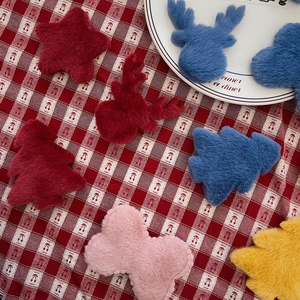 Macro detail of plush Christmas tree and reindeer ornaments on a checkered tablecloth