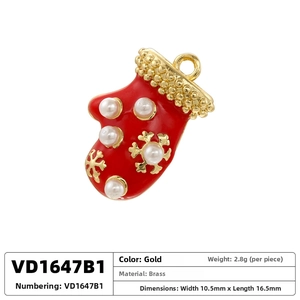 Detail of red enamel Christmas stocking charm with gold snowflake and pearls on brass
