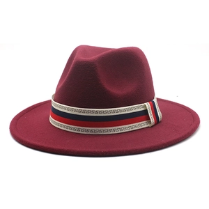 Detail of burgundy wide-brim wool fedora hat with geometric patterned ribbon band