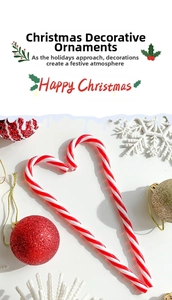 Detail of red and white twisted Christmas candy canes in a heart shape with festive decor