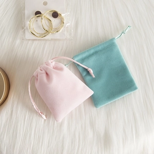 Detail of plush velvet drawstring jewelry pouches in soft pink and mint green colors