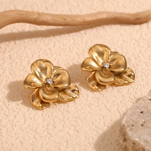 Detailed close-up of 18K gold-plated double-layer flower earrings with white rhinestones