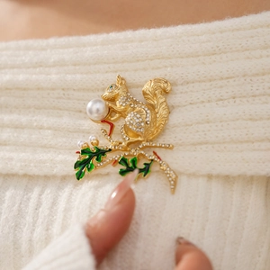 Broche écureuil vintage avec perles et cristaux sur un pull en maille blanche