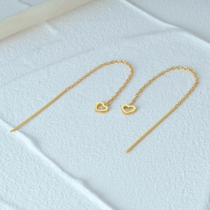 Detail of S925 silver heart tassel earrings with gold finish and delicate chain