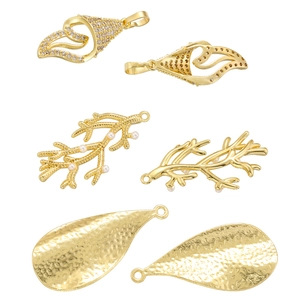 Detailed view of gold coral, leaf, and hammered drop pendants with pearls and zircons