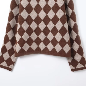 Detailed view of argyle pattern knit textures and ribbed hem on brown cardigan