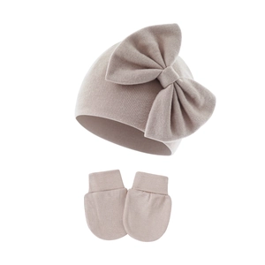 Detailed knit texture of pink baby hat with bow and anti-scratch mittens set