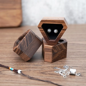 Detailed view of diamond-cut walnut wood jewelry boxes showcasing pearl earrings and texture