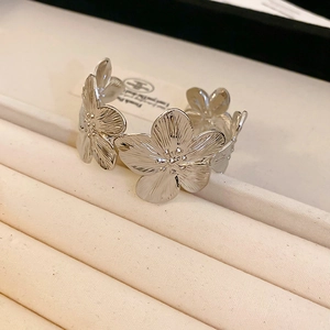 Detailed macro view of silver floral open cuff bangle with five petal flower textures