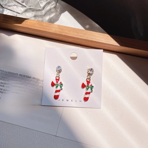 Detail of candy cane Christmas earrings with green bow and sparkling rhinestones