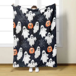 Close-up of soft flannel Halloween blanket featuring ghosts and pumpkin patterns