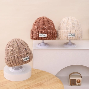 Close-up of ribbed knit beanies with polka dots and smile face label in autumn colors