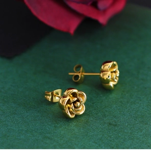 Macro view of vintage golden rose stud earrings with textured floral petal details