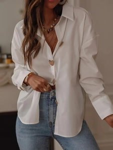 Detail of white long-sleeved shirt featuring elegant heart-shaped buttons and soft fabric