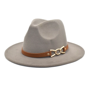 Detail of grey wool fedora featuring a brown leather strap and golden metal chain buckle