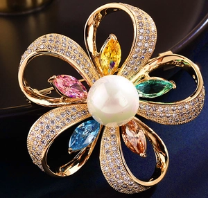 Détail d'une broche fleurie avec zircons colorés, strass micro-sertis et perle blanche