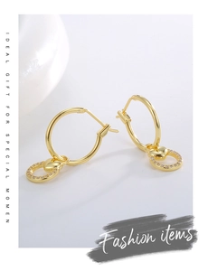 Detailed close-up of golden heart hoop earrings with cubic zirconia micro-inlay