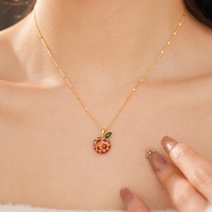 Macro shot of 14k gold plated apple pendant with vibrant colorful zircon pavé stones