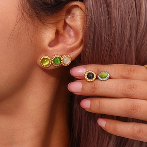 Close-up of vintage cat-eye stone earrings with gold and silver beaded metal settings