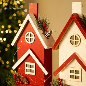 Set di casette natalizie in legno con luci LED, pigne e bacche rosse su sfondo festoso