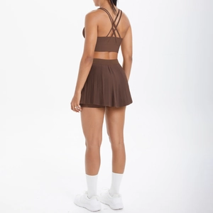 Détail macro de l'ensemble de sport marron avec brassière croisée et jupe plissée