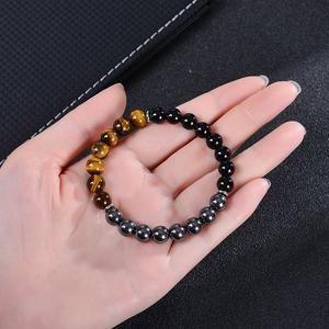 Triple bead bracelet with tiger eye, obsidian, and hematite on a leather background