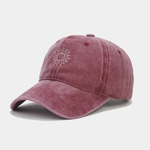 Détail de la broderie soleil et lune sur une casquette de baseball bordeaux délavée