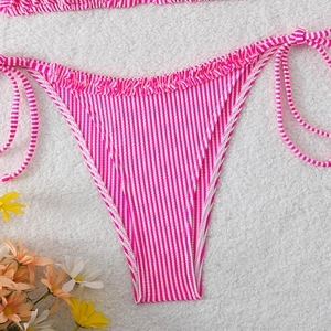 Detail of pink striped bikini bottoms featuring ruffled edges and side tie ribbons
