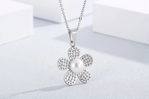 Macro detail of silver flower necklace with sparkling rhinestones and a white pearl center