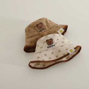 Detailed texture of corduroy kids bucket hat with bear embroidery and brand woven label