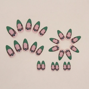 Detailed view of matte almond press-on nails with dark green French tips and floral vine patterns