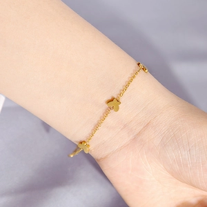 Detailed view of a gold-finish minimalist chain bracelet featuring three butterfly charms